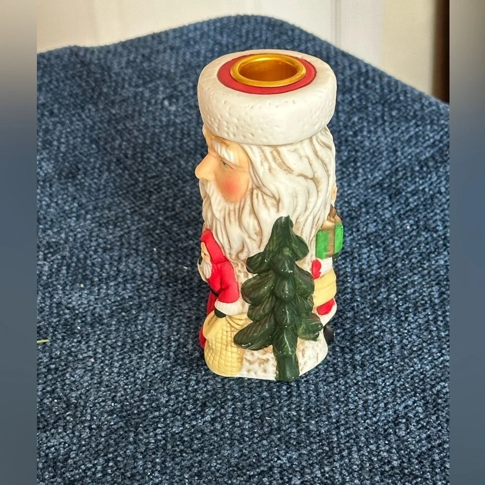 Cute Santa ceramic candleholder. Multiple smaller Santas surrounding the holder.